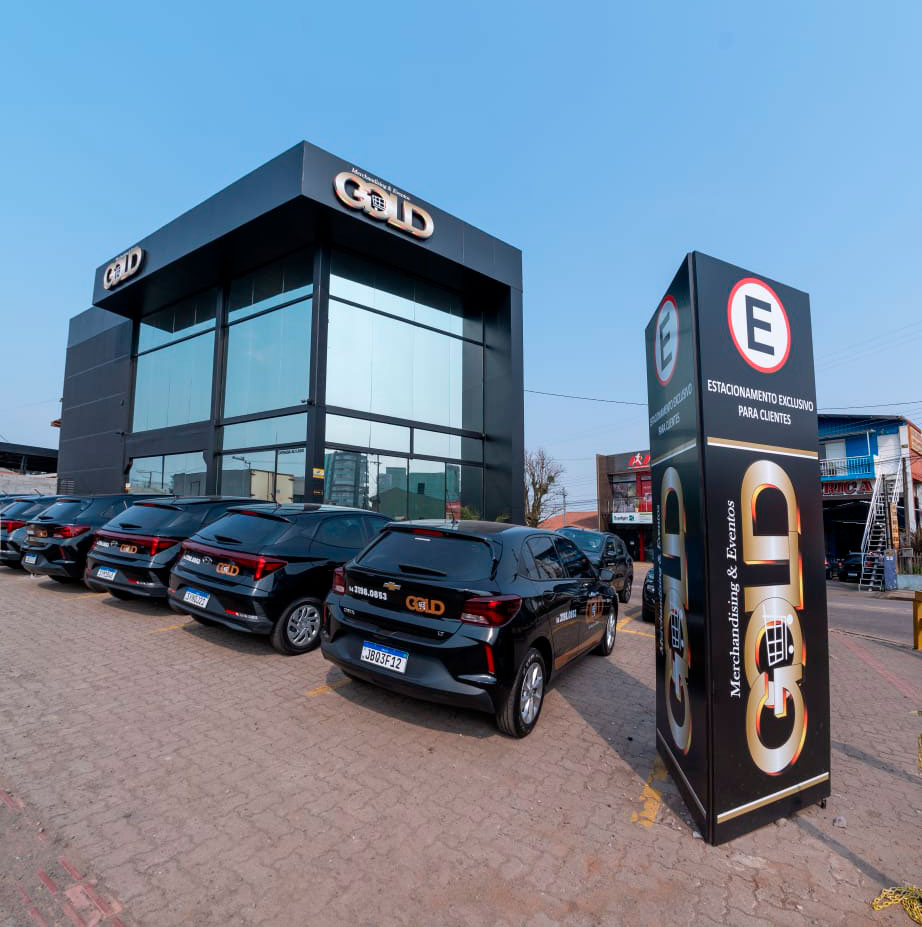 Sede própria da Gold Merchandising em Passo Fundo: prédio preto com letreiro dourado e frota identificada